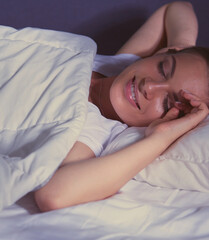 Beautiful young blonde woman sleeping in bed