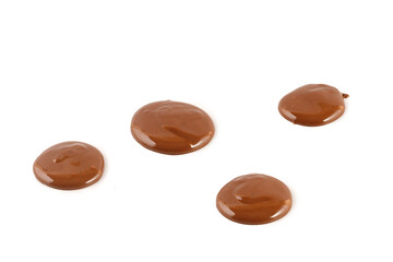 Chocolate drops of sweet liquid chocolate sauce isolated on white background. Melted drops of chocolate.