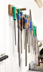 Set of rasps in a variety of sizes and types. Large rasps hanging off a mounted wood holder in the...