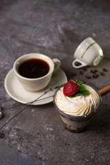 dessert in a glass with strawberries and a cup of tea top view