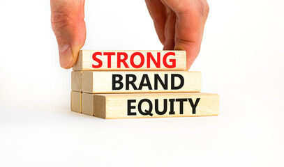 Strong brand equity symbol. Concept words Strong brand equity on wooden blocks on a beautiful white table white background. Businessman hand. Business, finacial and strong brand equity concept.