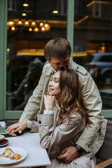 a couple in love walks in the autumn city against the background of buildings