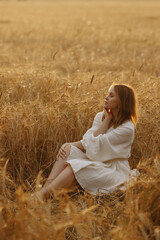 Portrait of a woman in a white dress in a field