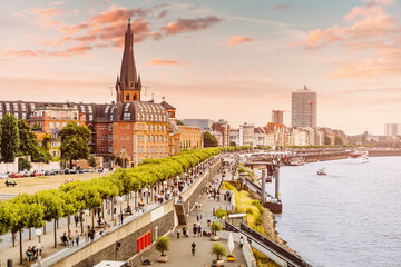 Sunset view of Dusseldorf city old town or Altstadt. Promenade on the banks of Rhine river. Travel and visit attractions in Germany. Popular city, center of Rheinland and Westphalia - obrazy, fototapety, plakaty