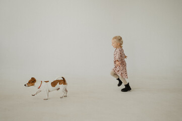 Little girl with a dog in the studio.