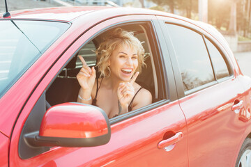 Fototapeta na wymiar Attractive blonde in a car showing keys.
