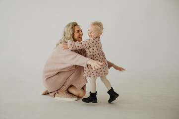 Mom kisses and hugs her daughter in the studio.