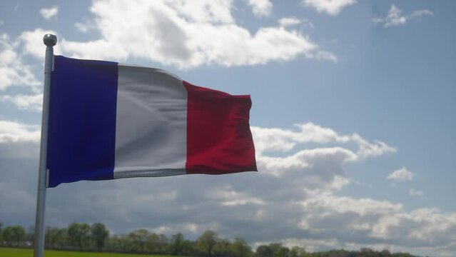 Flag of France waving at wind against beautiful blue sky