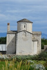 Fototapeta na wymiar Side view of one of the oldest pre-romanesque churches in Croatia, Church Of The Holy Cross in Nin city, Zadar district, during summer cloudy day.