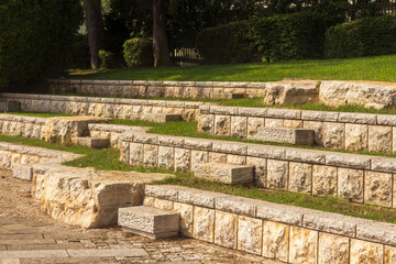Fototapeta na wymiar Stone amphitheater with steps in the park