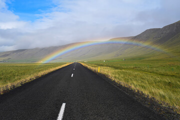 Iceland, rainbow over ring road, with hills and sheeps