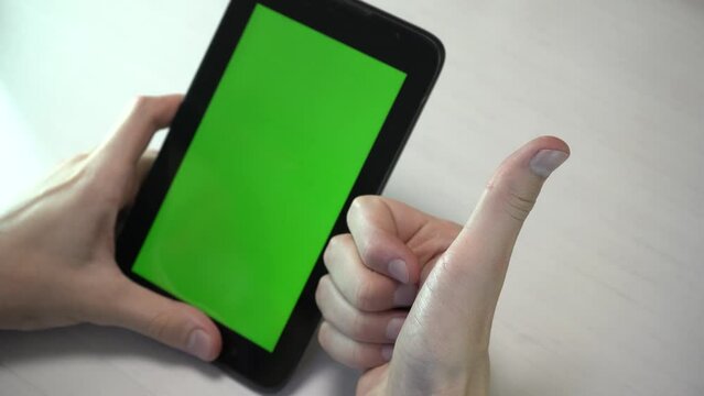 Human hands holding black tablet with greenscreen chromakey