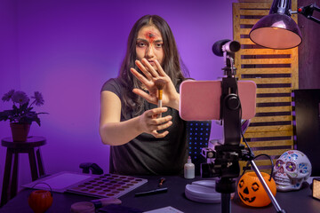 Teen girl showing a brush to camera giving an online makeup class for halloween