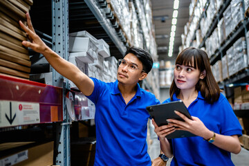 Two warehouse worker using digital tablets to check the stock inventory in large warehouses, a Smart warehouse management system, supply chain and logistic network technology concept.
