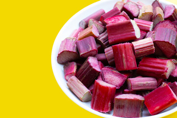 Fresh rhubarb on yellow background.