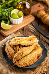 Fried sardines in the plate on the table.