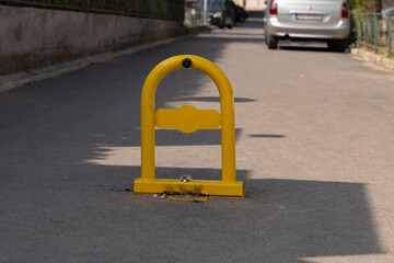 yellow metal fencing prohibiting entry to the parking space. yellow parking barrier on concrete. Mechanical barrier prohibiting the use of a parking space.