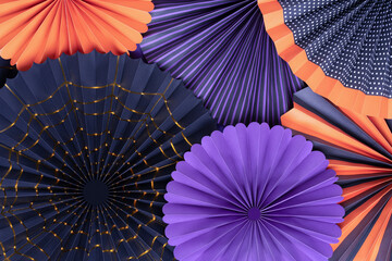 Halloween background from round paper fans. Bright paper fans in purple, orange and black colors of...