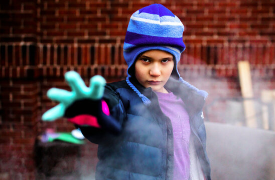 Serious boy standing in smoke pretends to cast spell