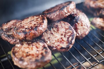 Grilled beef burger patties on a BBQ
