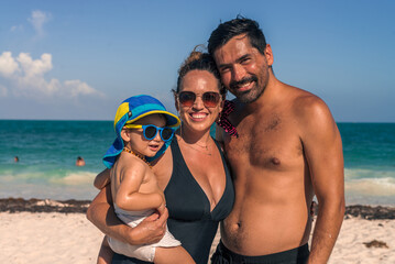 Obraz premium Portrait of a young latin family at the beach on a sunny afterno
