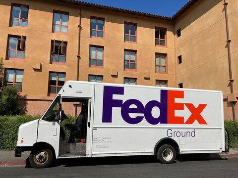 FedEx Ground delivery truck parked at residential building. Side view - California, USA - 2022