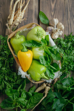 bell peppers and fresh basil, dill, parsley, cilantro, tomatoes, garlic, asparagus on a wooden table. top view. Flat lay