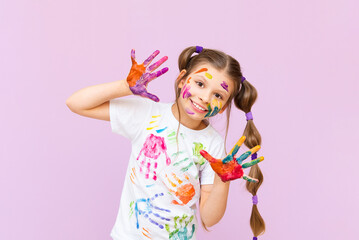 A child stained in multicolored paints will have to be creative. The concept of children's creativity on a pink isolated background.