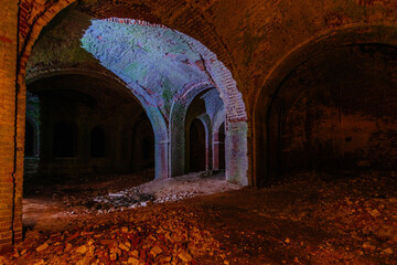 Dark corridor of old ancient abandoned red brick ruined historical building