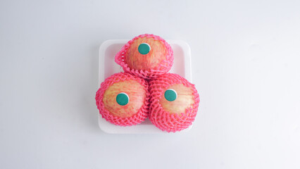 Three fresh apples with foam net fruit on white background