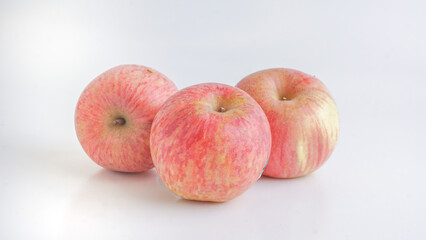 Three fresh Fuji apples on white background. Selective Focus