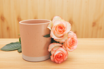 Pink cup of drink with rose flowers - vintage card with wooden background with copy space