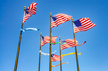 The Stars and Stripes, the national flag of The USA flying against a blue sky on a sunny day in summer.