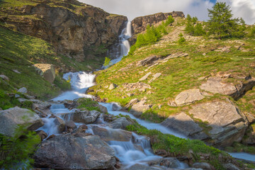 Ethereal waterfall and alpine meadows at springtime, Gran Paradiso Alps, Italy