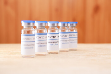 Coronavirus vaccine ampoules on the table - vaccination medical concept, health care