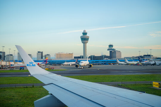 View of Amsterdam Airport Schiphol tower as seen from airplane taxiing on runway