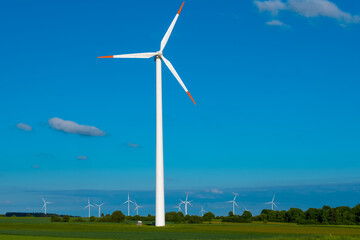 Fototapeta premium Wind generators in field.blades of wind generators.Alternative energy sources.Wind energy price.Green renewable energy cost.