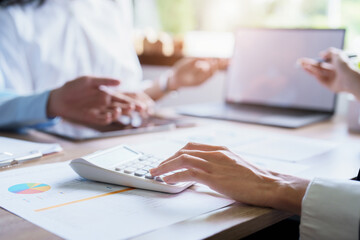Group business  use calculators, documents, computers to analyze work.