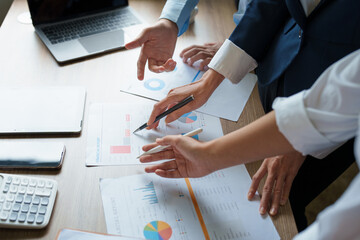 Group business  use calculators, documents, computers to analyze work.