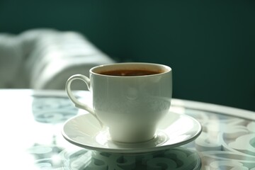 Cup of delicious aromatic coffee on table indoors, closeup