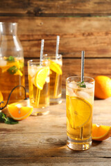 Delicious refreshing drink with orange slices on wooden table