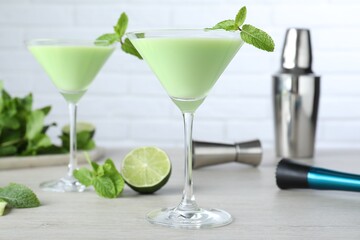 Delicious mint liqueur with green leaves on white wooden table