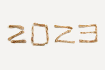 Happy New year 2023. New Year Concept welcoming New Year 2023 written by craft rope or jute on white background. Close-up. Two thousand twenty three