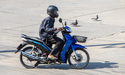 A man with helmet rides a motorcycle at the road