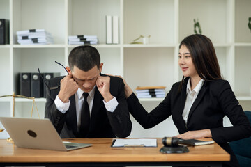 Asian businessman lawyers are stressed about working on legal matters and have a team or clients to sit and support them to find solutions to legal problems.