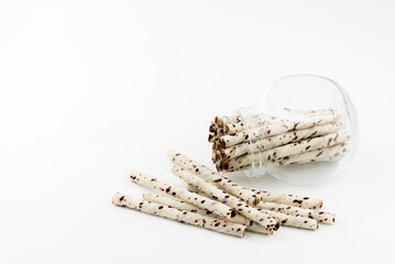 wafer rolls with chocolate in glass white background