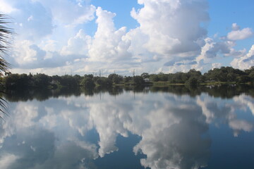 Wide shot of cloudscape reflection against the pond lake in the daytime