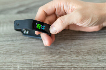 Fototapeta premium Close up shot of a man setting up a fitness wristband. Lifestyle