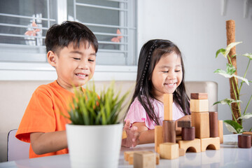 Children boy and girl playing with constructor wooden block building, Happy little kids play wood block stacking board game at home, activities learning creative, toys for preschool and kindergarten