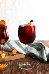 Glass of delicious mulled wine on wooden table